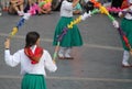 some young people walking around holding colorful kites in a circle