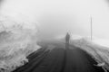 Somebody is walking on road leading through scenic countryside, Snow & fog at Grossglockner mountain, Austria