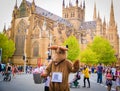 Somebody wearing Kangaroo costume , selling flowers at Sydney Hyde park with st mary`s cathedral church in the background.