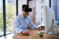 Someday he wont need a screen at all. Shot of a happy young businessman wearing a virtual reality headset while working Royalty Free Stock Photo