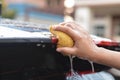 Someone hand catch old yellow sponge washing car spoiler