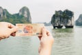 Someone hands showing 200,000 dong of Vietnamese banknotes with an iconic karst in Halong Bay. Royalty Free Stock Photo