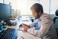 Someone has a message. a focused young businessman texting on his cellphone while being seated behind his desk in the Royalty Free Stock Photo