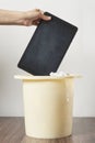 a person throwing a book into a bucket with tissues Royalty Free Stock Photo