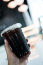 Someone holding a plastic cup of ice black coffee Royalty Free Stock Photo