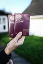 Someone holding 2 Portuguese passports with an out of focus background