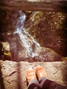 Someone`s boots overlooking a stream