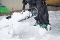 Someone is shoveling snow outside in winter while it is snowing