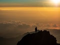 Someone Silhouette standing and sitting on top of the mountain Royalty Free Stock Photo