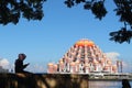 someone sitting while enjoying the beauty of the 99 dome mosque which is orange Makassar, Indonesia - 8 June 2022