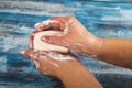 Someone is soaping their hands with a piece of toilet soap on a wooden background. Close up. Regular hand washing with soap is a Royalty Free Stock Photo