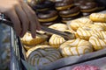 Someone takes a donut from a shelf in the confectionery department Royalty Free Stock Photo