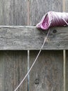 Skein of Pink Twine Resting on a Wooden Fence