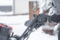 Someone uses a snowthrower outdoors in winter while it is snowing Royalty Free Stock Photo