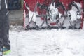 Someone uses a snowthrower outdoors in winter while it is snowing