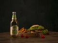 Somersby Apple Cider by Danish brewing company Carlsberg Group with fast food burger on a round wooden table