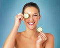 Sometimes the eyes need a pick me up. Studio portrait of a beautiful young woman covering her eye with a cucumber slice Royalty Free Stock Photo