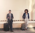 Sometimes we just have to wait a little. two businesspeople standing with their luggage and waiting for the train in the Royalty Free Stock Photo