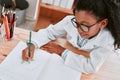 Sometimes you have to draw things into perspective. an adorable young school girl drawing a diagram in her exercise book