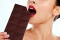Sometimes youve just gotta indulge. Studio shot of an unrecognizable young woman biting into a slab of chocolate against