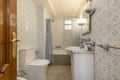 A somewhat old full bathroom with a frameless rectangular mirror