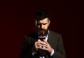 Sommelier with beard on burgundy background. Connoisseur with closed eyes Royalty Free Stock Photo