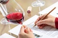 Sommelier evaluating red wine taking notes at table Royalty Free Stock Photo