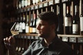 Sommelier looks at white wine in glass in cellar Royalty Free Stock Photo