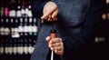 Sommelier opens cork of bottle of red wine with corkscrew, concept banner tasting Royalty Free Stock Photo