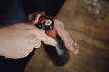 Sommelier opens cork of bottle of red wine with corkscrew, top view Royalty Free Stock Photo