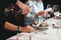 Sommelier pouring champagne into glass at wine tasting Royalty Free Stock Photo