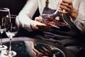 Sommelier pouring red wine from bottle into decanter at table in restaurant Royalty Free Stock Photo