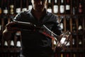 Sommelier pouring red wine in decanter, backlight shot