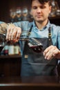 Sommelier pouring wine into glass from mixing bowl. Male waiter Royalty Free Stock Photo