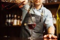 Sommelier pouring wine into glass from mixing bowl. Male waiter Royalty Free Stock Photo