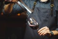 Sommelier pouring wine into glass from mixing bowl. Male waiter Royalty Free Stock Photo