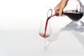 Sommelier pours red wine from decanter to wineglass on white background. Royalty Free Stock Photo