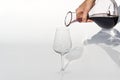 Sommelier pours red wine from decanter to wineglass on white background. Royalty Free Stock Photo