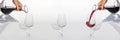 Sommelier pours red wine from decanter to wineglass on white background. panoramic shoot or banner. Royalty Free Stock Photo