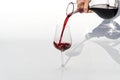 Sommelier pours red wine from decanter to wineglass on white background. Royalty Free Stock Photo