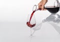 Sommelier pours red wine from decanter to wineglass on white background. Royalty Free Stock Photo