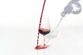 Sommelier pours red wine from decanter to wineglass on white background. spilling red wine past the glass on a white Royalty Free Stock Photo