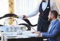 The sommelier pours the wine into the decanter near the guest in the restaurant Royalty Free Stock Photo