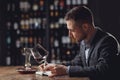 Sommeliers male hold glass red wine tasting and making notes degustation card Royalty Free Stock Photo