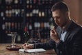 Sommeliers male tasting red wine and making notes aroma degustation card Royalty Free Stock Photo