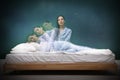 Somnambulist rising from bed near dark wall indoors, multiple exposure. Sleepwalking Royalty Free Stock Photo