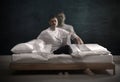 Somnambulist rising from bed near dark wall indoors, multiple exposure. Sleepwalking Royalty Free Stock Photo