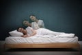 Somnambulist rising from bed near green wall indoors, multiple exposure. Sleepwalking Royalty Free Stock Photo
