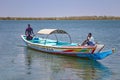 Somone lagoon, Senegal- April 26 2019: Two boys are sailing on a typical wooden colorful canoe in Senegal, Africa