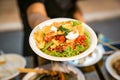 Somtum; Spicy papaya salad with boiled corn in paper dish at foodtruck street food event., Bangkok, Thailand